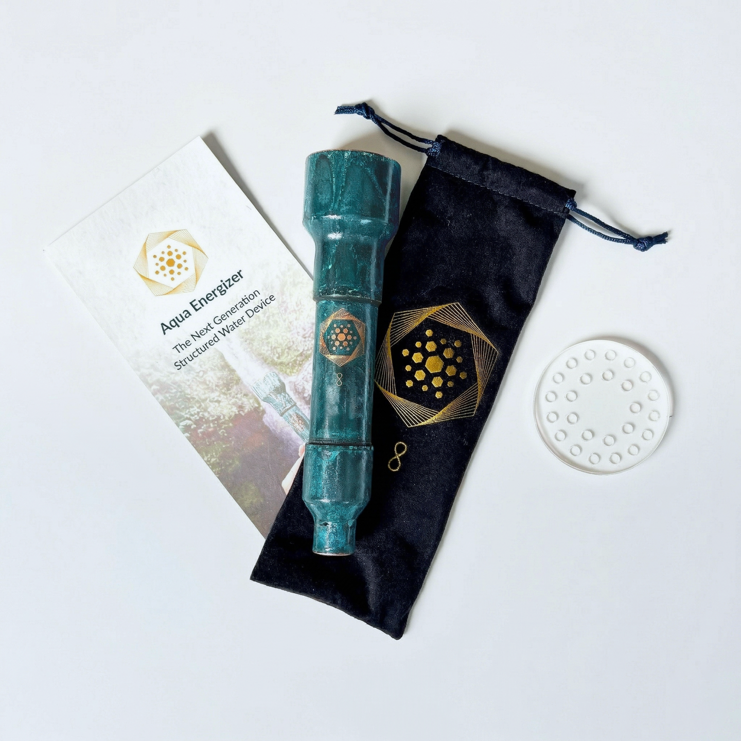 The Aqua Energizer On-the-Go Structured Water Device by Aqua Energizer, with a teal cylindrical design, comes with a black drawstring pouch, white “Aqua Energizer” card, and round white disc—tools crafted for cellular vitality and natural hydration.