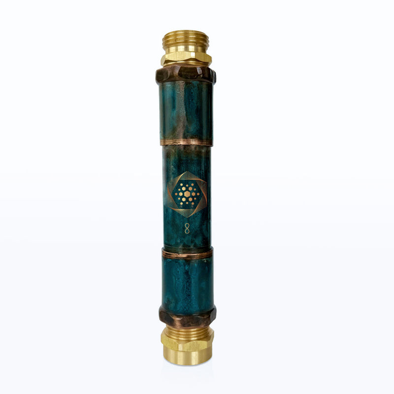 The Aqua Energizer Garden Structured Water Device by Aqua Energizer features a teal cylindrical body, brass fittings, and a gold geometric symbol with the number 8 in the center for enhanced cellular hydration.